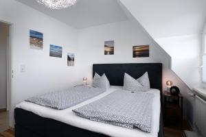 een slaapkamer met een groot bed met witte lakens en kussens bij Nordstern in Laboe