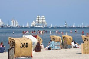 mensen op een strand met stoelen en boten in het water bij Nordstern in Laboe