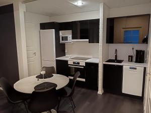 une petite cuisine avec une table et des chaises. dans l'établissement Salonharlekiini, à Lieksa