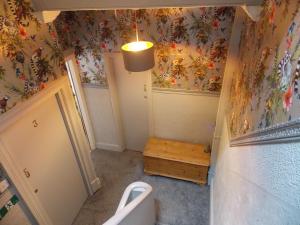 a bathroom with a toilet and flowers on the wall at The Rockley Hotel in Blackpool