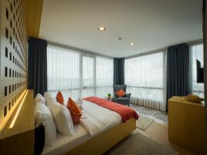a bedroom with a large bed and large windows at Mihman Hotel in Tuzla