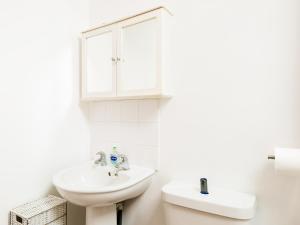 a white bathroom with a sink and a mirror at Pass the Keys Self Contained 1 Bed Coach House in Leamington Spa