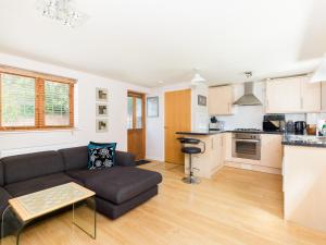 ein Wohnzimmer mit einem Sofa und einer Küche in der Unterkunft Pass the Keys Self Contained 1 Bed Coach House in Leamington Spa