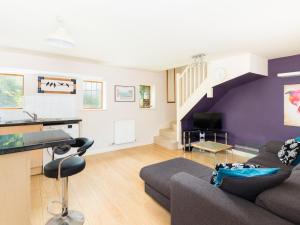 a living room with a couch and a staircase at Pass the Keys Self Contained 1 Bed Coach House in Leamington Spa