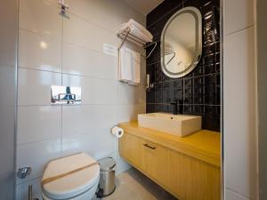a bathroom with a toilet and a sink and a mirror at Mihman Hotel in Tuzla