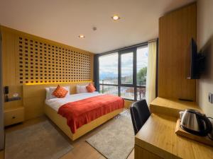 a bedroom with a bed and a large window at Mihman Hotel in Tuzla