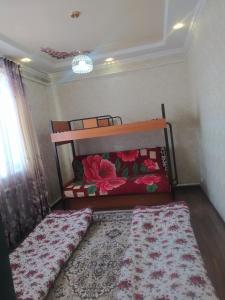 een kleine slaapkamer met een bed en een tapijt bij Jusup Guest House, Hostel in Dzhangyaryk