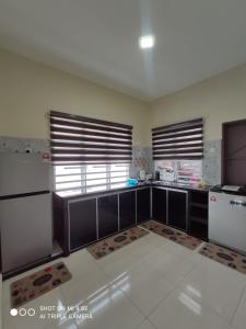 a kitchen with black and white appliances and windows at MUSLlM ONLY Pool Wifi 3 aircond room Hospital Sultanah Bahiyah in Alor Setar
