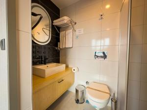 a bathroom with a toilet and a sink at Mihman Hotel in Tuzla