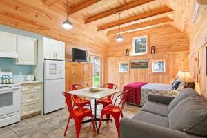 a kitchen and a living room with a couch and a table at Avonlea Forest Hill Cottages in New Glasgow