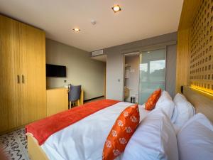 a bedroom with a bed with orange pillows on it at Mihman Hotel in Tuzla