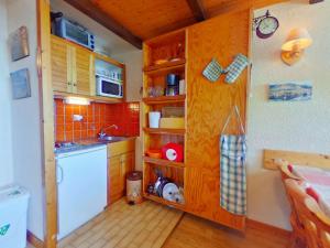 a small kitchen with wooden cabinets and a sink at Appartement Les Saisies, 1 pièce, 4 personnes - FR-1-594-201 in Hauteluce