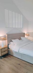 ニヨンにあるCoco Marco Hôtelのベッドルーム1室(白いベッド1台、ナイトスタンド、ランプ2つ付)