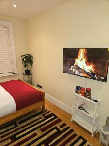 a bedroom with a bed and a fire in a fireplace at HEATHROW MANSION SHUTTLES in Uxbridge