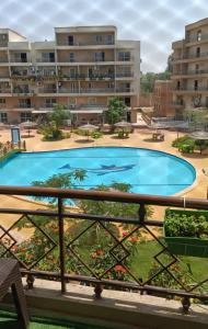 a view of the pool from the balcony of a apartment building at Pyramids and Museum Resort /villa in Giza