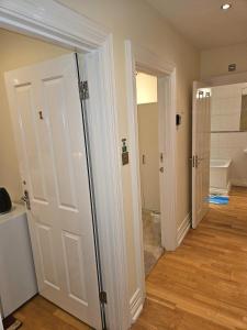 a bathroom with two doors and a toilet at HEATHROW MANSION SHUTTLES in Uxbridge