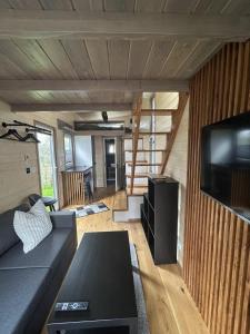 uma sala de estar com um sofá e uma televisão de ecrã plano em Tiny House em Roxheim