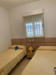 um quarto com duas camas e uma janela em Apartamento vacacional cerca al mar - OROPESA DEL MAR em Oropesa del Mar