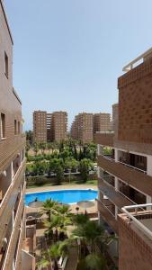 uitzicht op een zwembad in een stad met hoge gebouwen bij Apartamento vacacional cerca al mar - OROPESA DEL MAR in Oropesa del Mar
