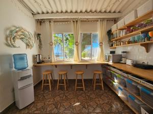 a kitchen with two stools and a counter with a window at Sunset Surf Villa in La Libertad