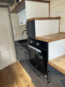 una cocina con horno negro en una casa pequeña en Tiny House en Roxheim