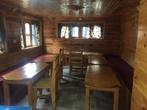 un comedor con mesas de madera y sillas en una cabaña en Tribeni Lodge Restaurant And Bar, en Phakding