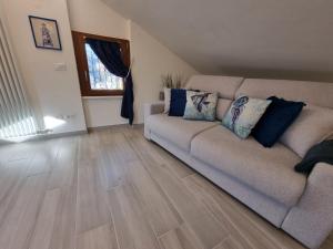 sala de estar con sofá y suelo de madera en Mansarda al mare, en Rapallo