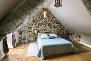 ein Schlafzimmer mit einem Bett in einer Steinmauer in der Unterkunft La petite corbière - Chez Hélène - Gîtes en baie in Jullouville-les-Pins