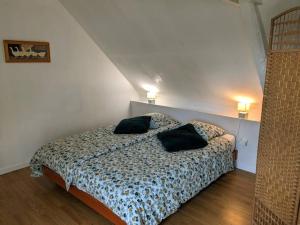 ein Schlafzimmer mit einem Bett mit zwei Kissen darauf in der Unterkunft La petite corbière - Chez Hélène - Gîtes en baie in Jullouville-les-Pins