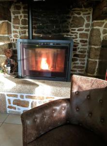 einem Ledersessel vor einem Steinkamin in der Unterkunft La petite corbière - Chez Hélène - Gîtes en baie in Jullouville-les-Pins