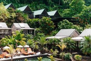 a resort with a pool and chairs and trees at Rabot Hotel From Hotel Chocolat in Soufrière