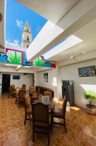 a waiting room with tables and chairs and a clock tower at Hotel La Catedral Mérida in Mérida