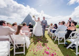 une mariée et un marié se promenant dans l'allée à leur mariage dans l'établissement Rabot Hotel From Hotel Chocolat, à Soufrière