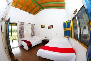 1 dormitorio con 2 camas y ventana en Finca Hotel Betulia, en La Tebaida