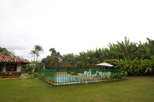 a fence with an umbrella in a yard at Finca Hotel Betulia in La Tebaida +11 photos