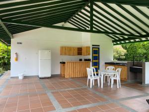 patio con mesa y sillas y cocina en Finca Hotel Betulia, en La Tebaida