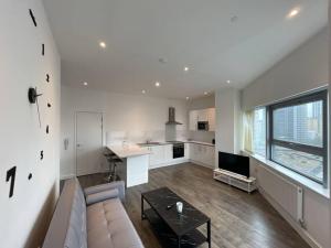 a large living room with a couch and a kitchen at Bright & Spacious Flat In London in Croydon