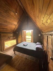 Benedito NovoにあるRecanto da Liberdadeの木造キャビン内の小さなベッドルーム(ベッド1台付)