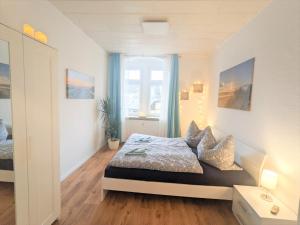 a bedroom with a bed and a window with blue curtains at Urlaubsmagie - Helle Wohnung mit Garten & Pool - R3 in Rathmannsdorf
