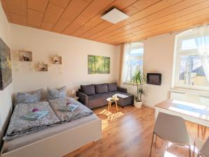 ein Wohnzimmer mit einem Bett und einem Sofa in der Unterkunft Urlaubsmagie - Helle Wohnung mit Garten & Pool - R3 in Rathmannsdorf