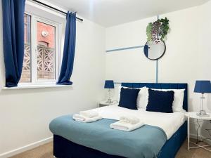 a bedroom with a blue and white bed with towels on it at Perfect Place For Contractors & Family Stays in Luton