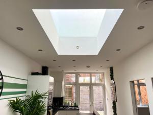 a kitchen with a ceiling with a skylight at Perfect Place For Contractors & Family Stays in Luton