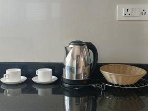 a coffee maker sitting on a counter with two cups at CasaBonito 3BHK Villa in Mysore