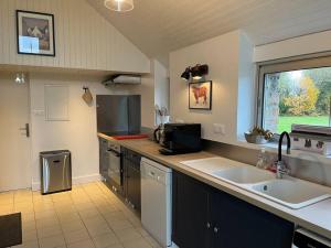 a large kitchen with a sink and a window at Ty Breiz in Plouézec