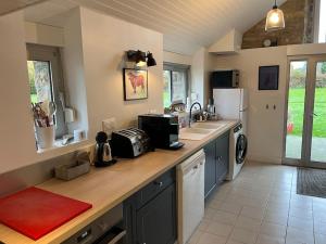 a kitchen with a counter with a sink and a refrigerator at Ty Breiz in Plouézec +11 photos