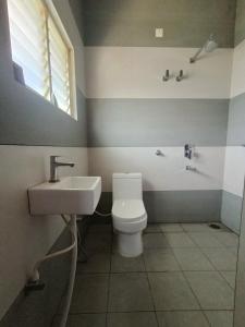 a bathroom with a toilet and a sink at CasaBonito 3BHK Villa in Mysore