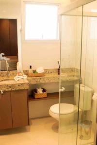 uma casa de banho com um WC e uma cabina de duche em vidro. em Novíssimo ,ótima localização. em Aracaju