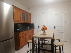 uma cozinha com uma mesa com cadeiras e um frigorífico em Happy house em Tourcoing