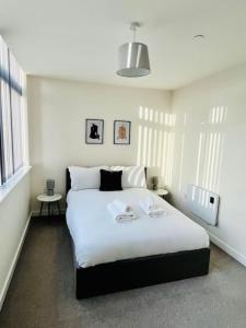 een slaapkamer met een groot wit bed in een kamer bij Old Trafford: Self-Serviced One Bedroom Apartment in Manchester
