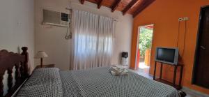 a bedroom with a bed with a television and a window at Costas del Paraiso in Colón